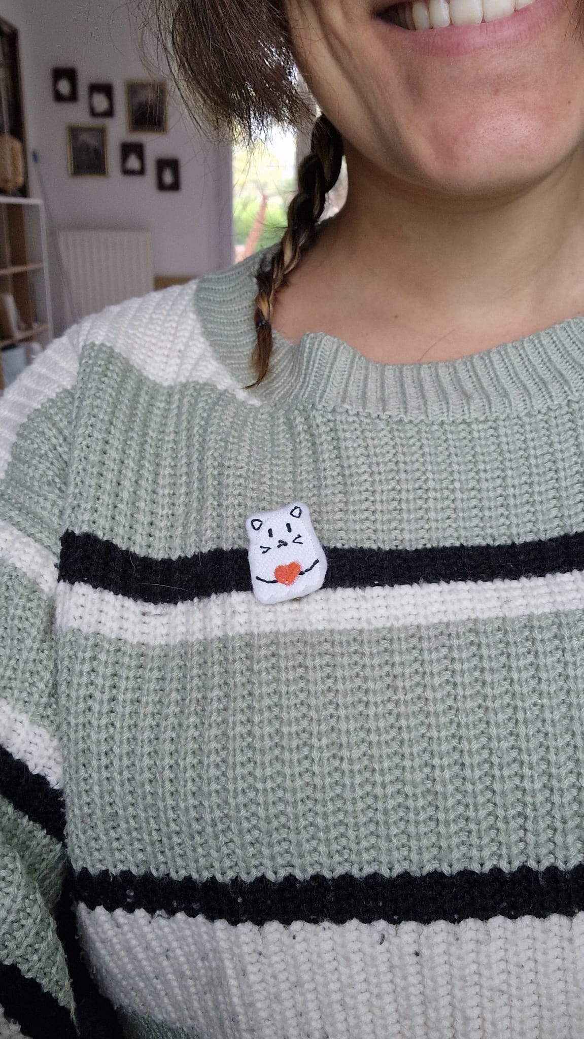 Photo d'une broche chat fantôme sur un pull gris