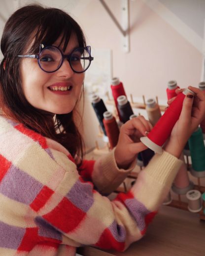 Photo de Coline la créatrice avec une bobine de fil